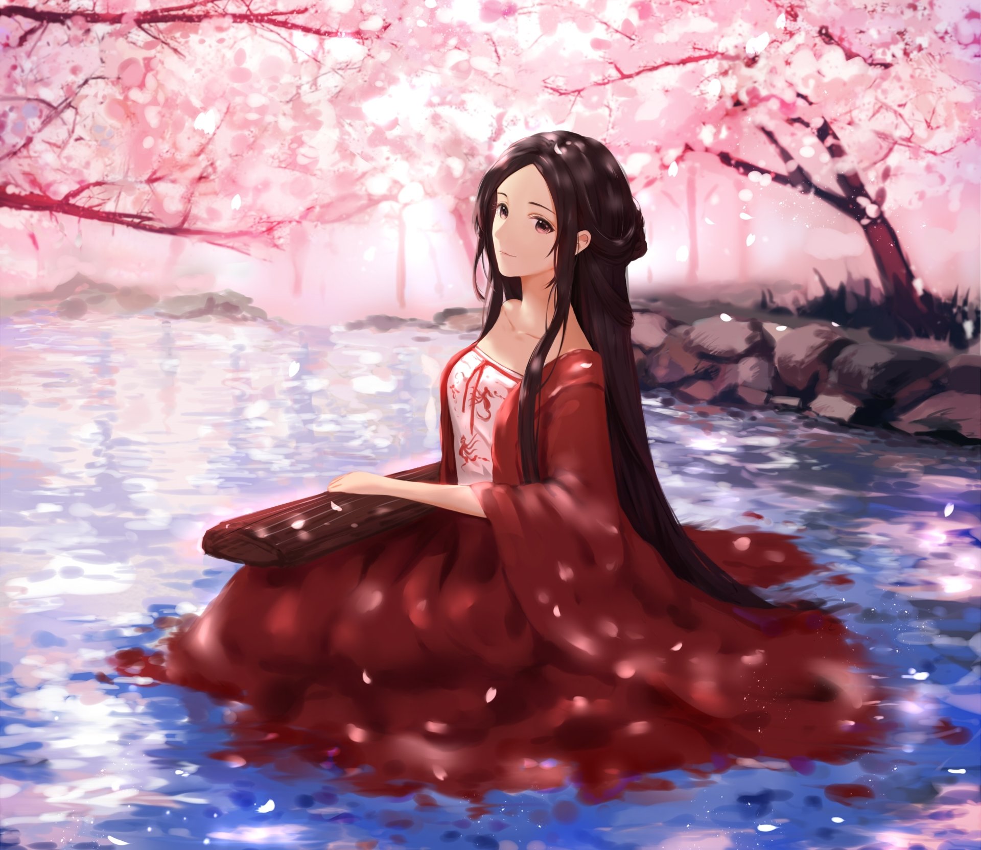 Anime original 2K Quad HD desktop wallpaper: long brown‑haired girl with brown eyes smiling in a red kimono, sitting in water beneath falling cherry blossoms.