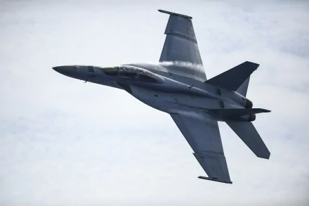 HD desktop wallpaper featuring a Boeing F/A-18E/F Super Hornet jet fighter in flight against a cloudy sky, showcasing its sleek military warplane design.