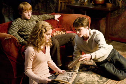 Harry Potter, Hermione Granger, and Ron Weasley are gathered in a cozy room, deeply engrossed in a discussion. This HD wallpaper is from the movie Harry Potter and the Half-Blood Prince.