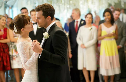 HD wallpaper of a wedding scene from Fifty Shades Freed with a couple dancing and guests in the background.
