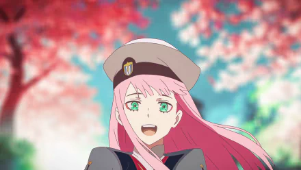 Zero Two from Darling in the FranXX, depicted in an anime style with pink hair and green eyes, smiles joyfully against a vibrant backdrop of pink and blue hues. This HD desktop wallpaper features this popular character.