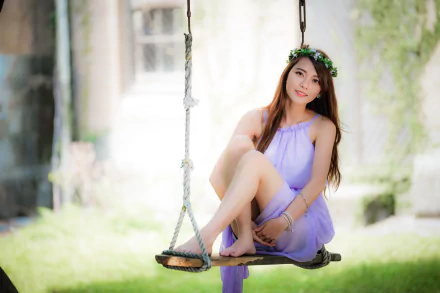 A smiling Asian woman with long brunette hair wearing a purple dress sits gracefully on a swing, captured with a soft depth of field in a 4K Ultra HD wallpaper.