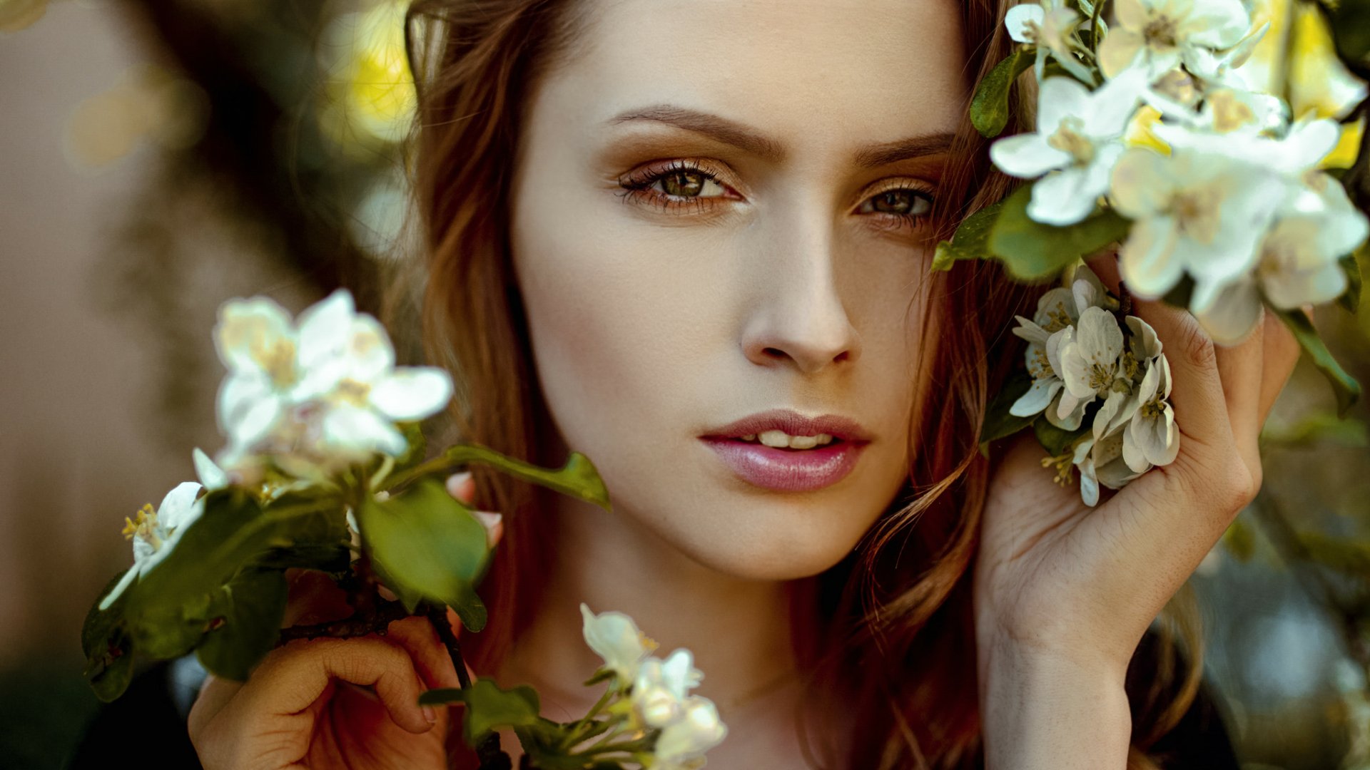 HD desktop wallpaper featuring a close-up of a woman's face surrounded by white blossoms, capturing natural beauty and delicate floral details.