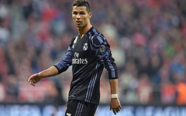 HD desktop wallpaper of Portuguese soccer player Cristiano Ronaldo during a match, clicked mid-action on the field wearing a football uniform.