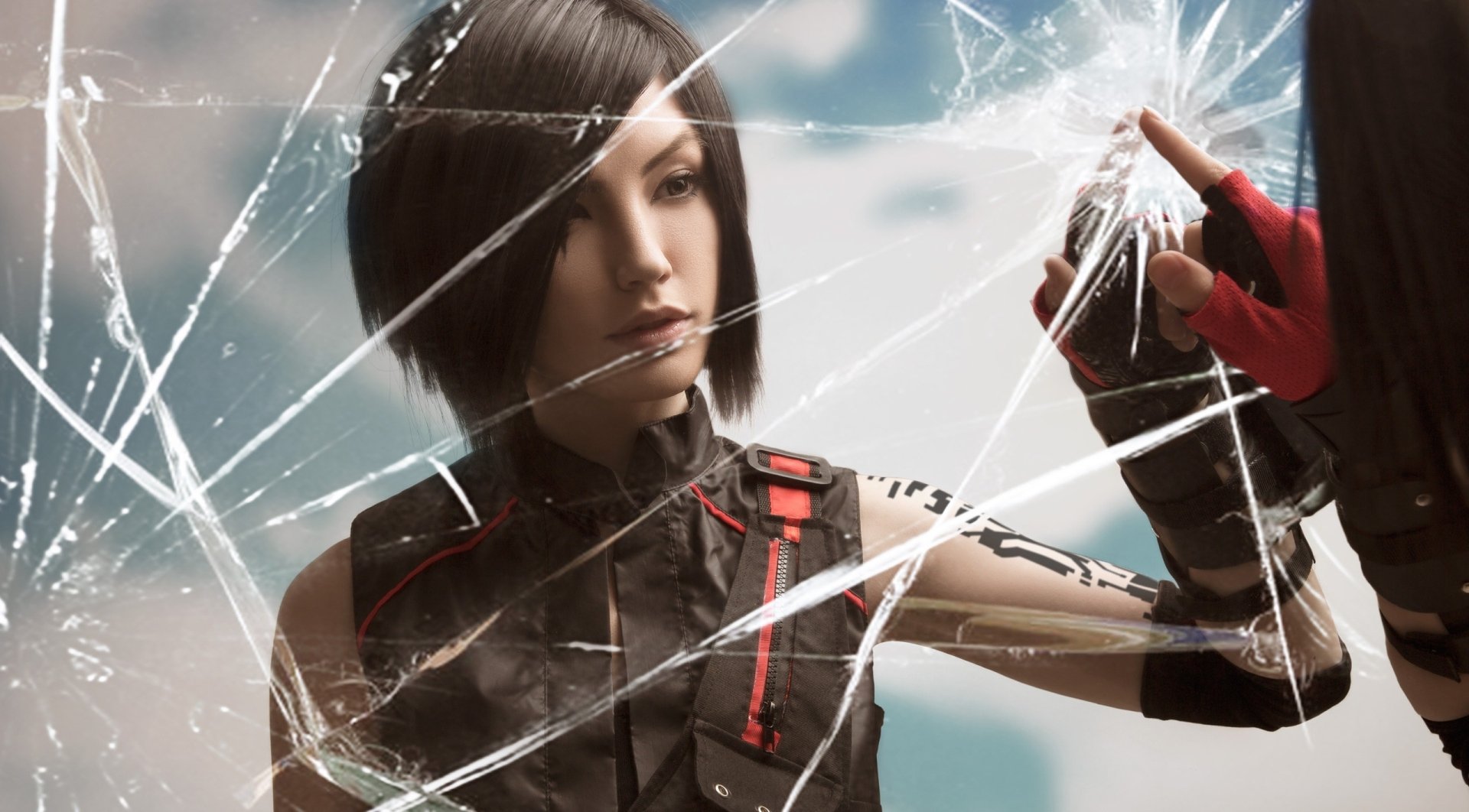 HD wallpaper of a woman cosplaying Faith Connors from Mirror's Edge, with shattered glass effects adding dynamic depth to the PC desktop background.