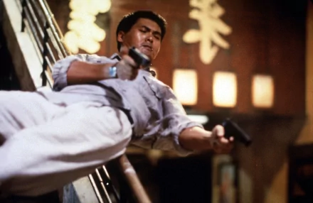 Hard Boiled (movie) action: a man in a white shirt fires dual pistols while sliding down a banister — 2K Quad HD PC desktop wallpaper/background.