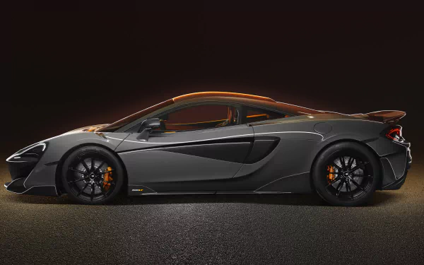 Silver McLaren 600LT supercar in side profile on a dark asphalt backdrop — high-detail 8K Ultra HD PC desktop wallpaper and background.