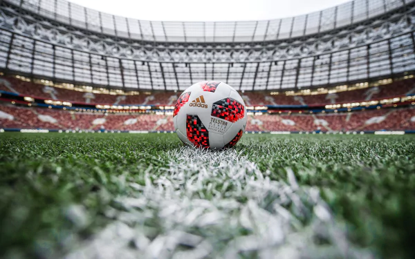 HD desktop wallpaper of a soccer ball centered on the grass field inside a large stadium, capturing the excitement of sports and the game.