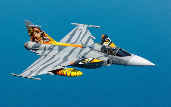 HD desktop wallpaper of a Saab JAS 39 Gripen military jet fighter warplane flying against a clear blue sky.