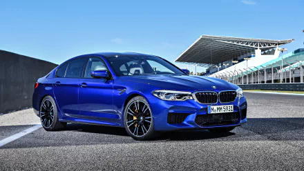 A vibrant blue BMW M5 parked on a racetrack under a clear sky, captured in 4K Ultra HD for a PC desktop wallpaper background.