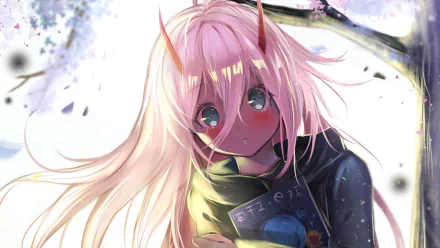 An HD desktop wallpaper featuring Zero Two from the anime Darling in the FranXX, with her pink hair flowing and blush on her cheeks, against a serene background with branches and petals.