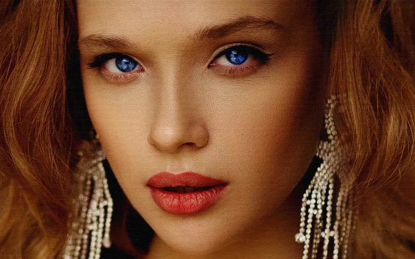 Close-up 4K Ultra HD portrait of a woman with striking blue eyes, red lipstick, and wavy hair, wearing intricate dangling earrings.