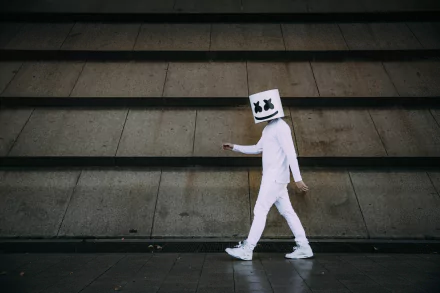 HD PC desktop wallpaper featuring Marshmello DJ in his signature white outfit and helmet, walking against a concrete stair backdrop with a minimalist urban vibe.