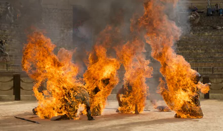 Daenerys Targaryen in Meereen (Game of Thrones) — three figures ablaze in an arena, fiery 2K Quad HD PC desktop wallpaper/background.