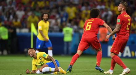 HD wallpaper featuring Neymar in Brazil colors, on the ground during a match, with opponents in red nearby.