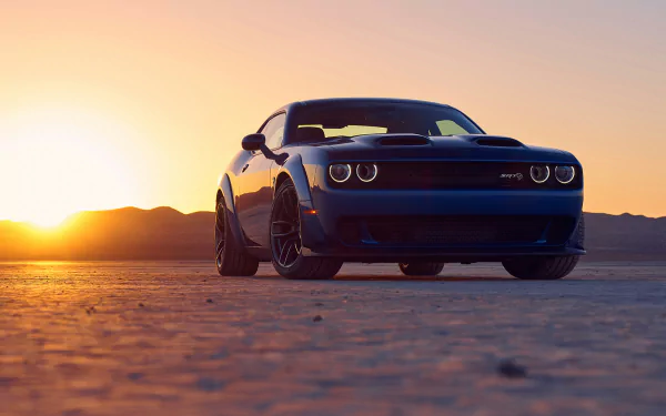A Dodge Challenger SRT Hellcat parked on a desert plain at sunset, captured in an HD PC desktop wallpaper with warm golden light and a clear sky.