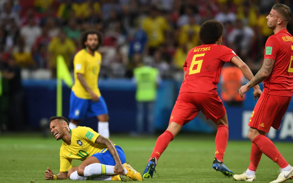 HD wallpaper featuring Neymar in Brazil colors, on the ground during a match, with opponents in red nearby.