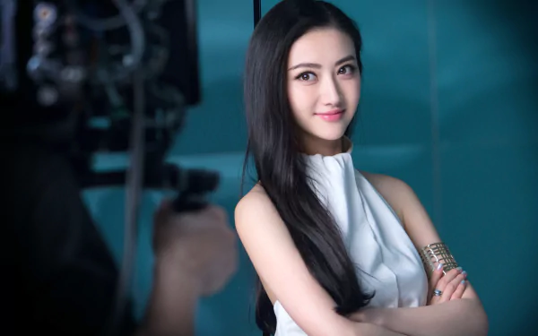 HD desktop wallpaper featuring a poised individual, tagged as Jing Tian, against a teal backdrop with camera equipment partially visible.