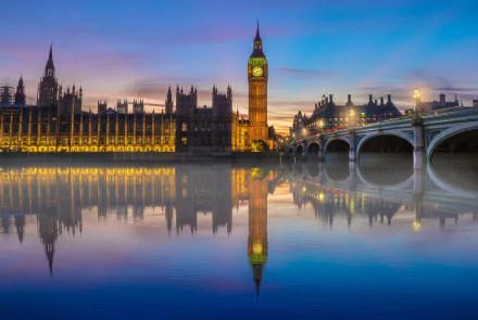 HD desktop wallpaper of Big Ben in London reflected in the Thames River at dusk. The image showcases the iconic building and bridge with a serene water reflection, capturing the essence of the United Kingdom's capital.
