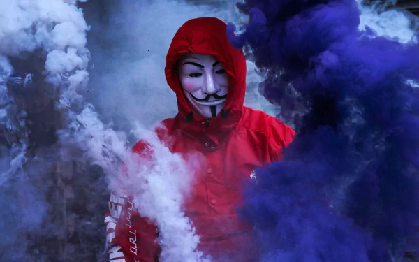 A striking HD wallpaper featuring a figure in a Guy Fawkes mask, shrouded in colorful smoke, symbolizing anonymity and technology.
