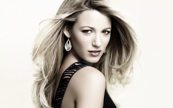 Blake Lively poses confidently in this striking HD desktop wallpaper, showcasing her long, flowing hair and elegant earrings against a minimalist background.