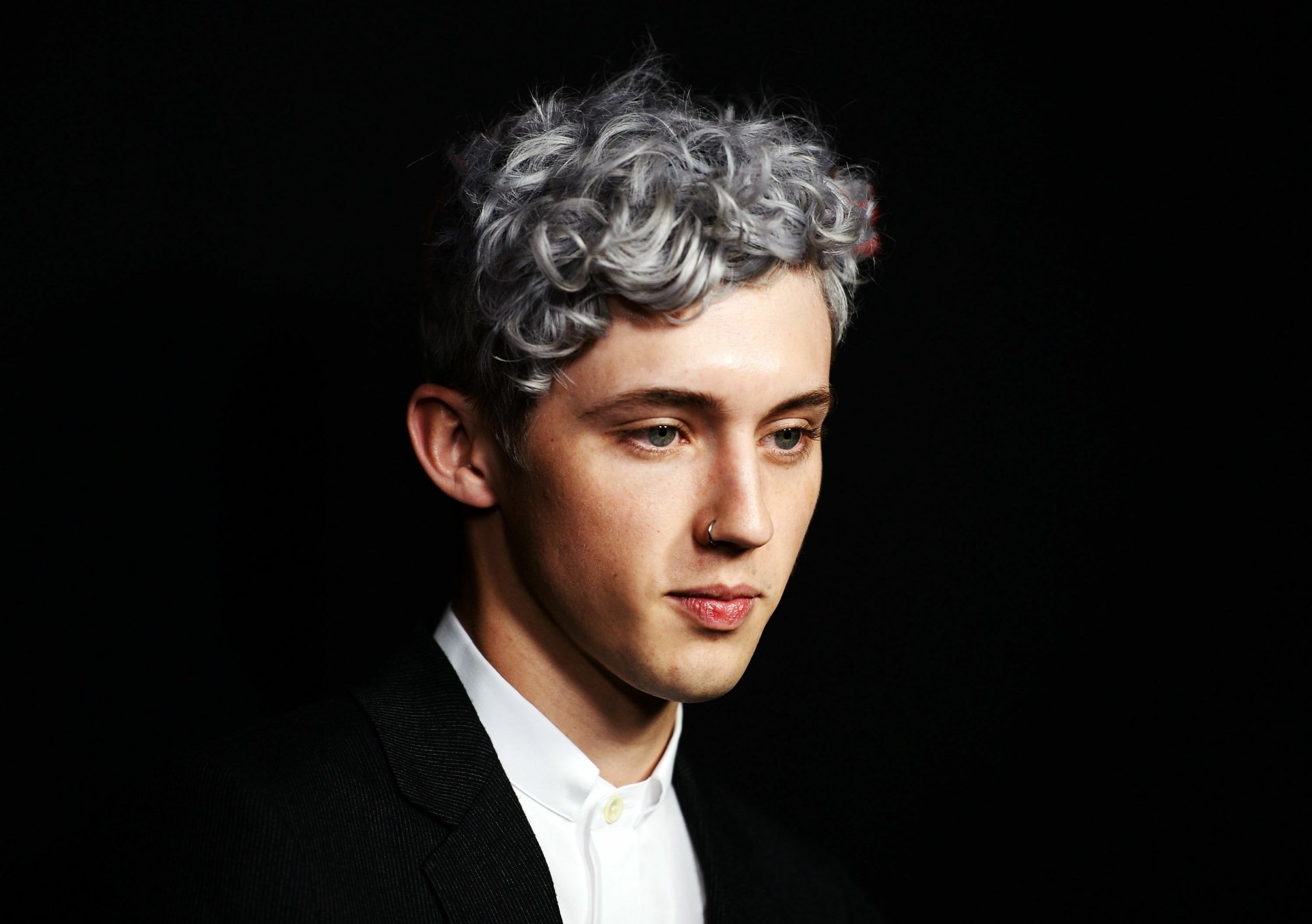 HD desktop wallpaper featuring a person with silver hair and a black jacket against a dark background.
