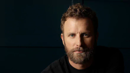 HD desktop wallpaper featuring a portrait of a man with a beard against a dark background.