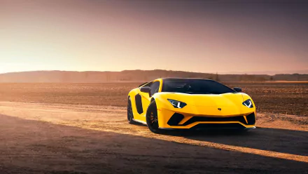 A yellow Lamborghini Aventador S supercar positioned on a desert road at sunset, showcased in stunning 4K Ultra HD desktop wallpaper quality.