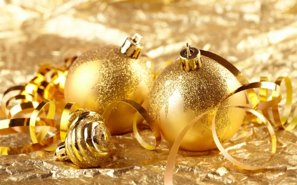 Golden Christmas ornaments glisten against a shimmering backdrop, embodying the spirit of the holiday season. This HD desktop wallpaper adds a festive touch to any screen.