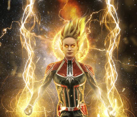 Captain Marvel movie 2K Quad HD desktop wallpaper: the heroine in glowing cosmic armor, eyes aflame, surrounded by golden energy arcs and a radiant cosmic backdrop.