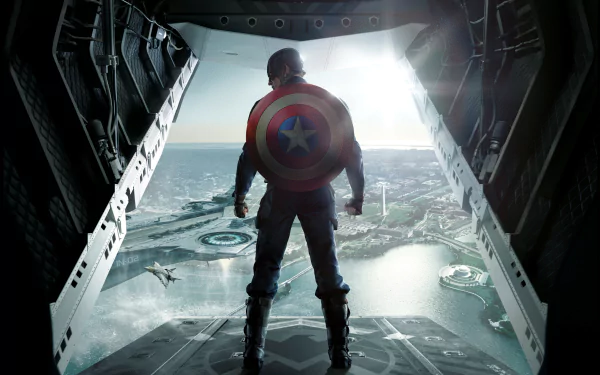 HD wallpaper of Captain America (Chris Evans) from Captain America: The Winter Soldier, standing in the open ramp of an aircraft, looking out over a cityscape with his shield on his back.