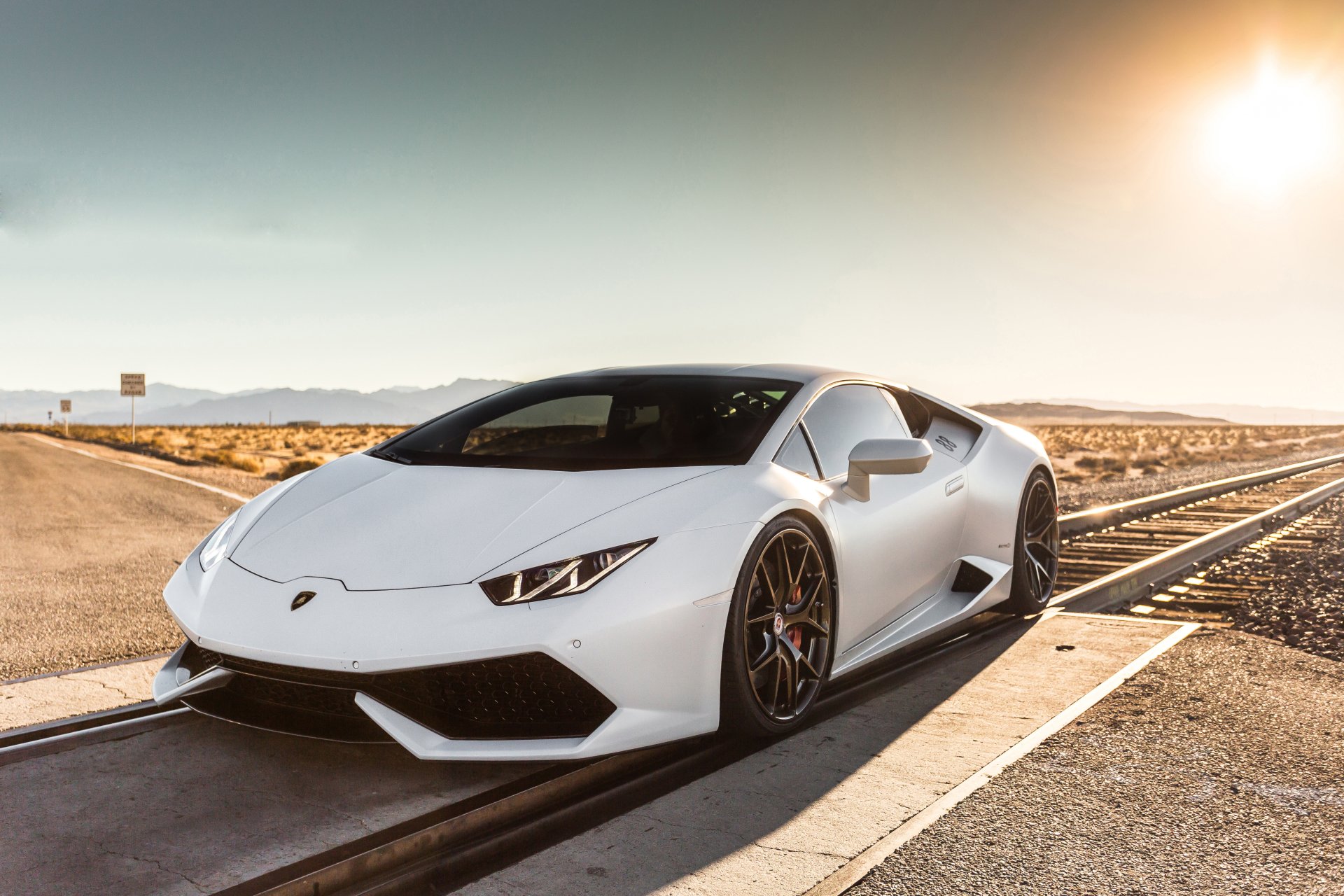 White Lamborghini Huracan sports vehicle parked on a desert road at sunset — 5K Ultra HD PC desktop wallpaper background.