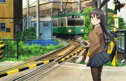 HD wallpaper of Mai Sakurajima from Rascal Does Not Dream of Bunny Girl Senpai in a school uniform with bunny ears, standing by train tracks.