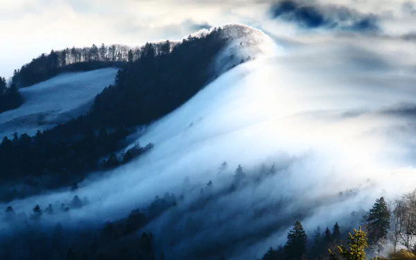 Snow-covered mountain slopes partially veiled by clouds under soft light, captured in stunning 8K Ultra HD for a breathtaking nature desktop wallpaper.