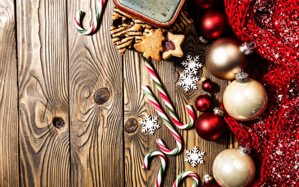 4K Ultra HD holiday wallpaper featuring Christmas ornaments, baubles, candy canes, gingerbread cookies, and festive decorations on a rustic wooden background.