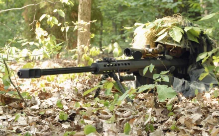 A U.S. Army infantry sniper, camouflaged in foliage, positioned in a forest with a sniper rifle, ready for action. High-definition desktop wallpaper and background. Tags: war, military.