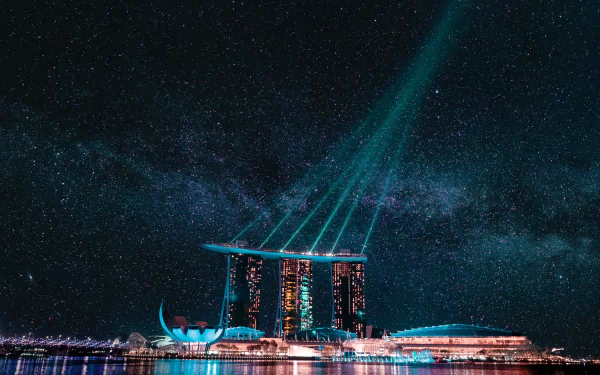 Night view of Marina Bay Sands in Singapore with a starry sky and vibrant light beams over the marina, captured in 4K Ultra HD.