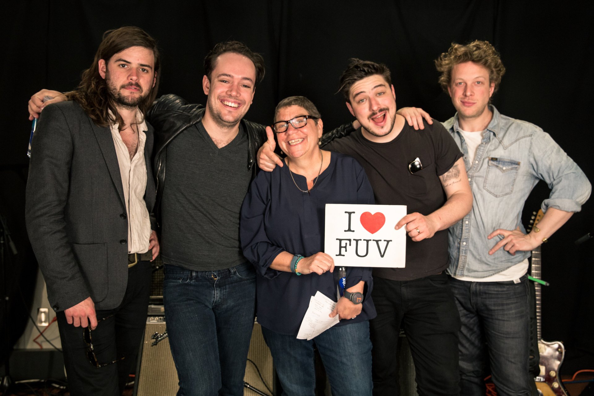 HD desktop wallpaper and background featuring Mumford & Sons posing with a person holding an I ❤️ FUV sign.