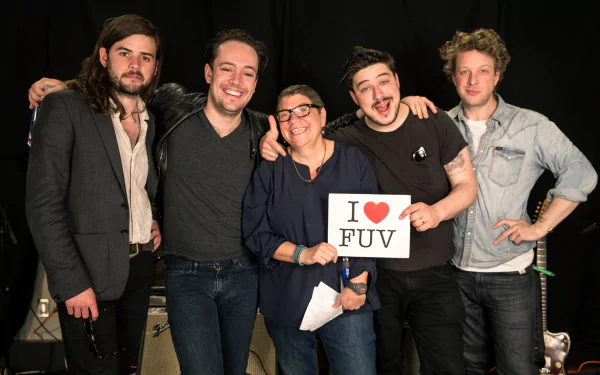 HD desktop wallpaper and background featuring Mumford & Sons posing with a person holding an I ❤️ FUV sign.