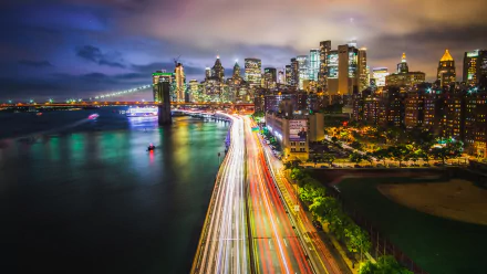 Time-lapse HD wallpaper of the Brooklyn Bridge and Manhattan skyscrapers at night in New York City, USA, showcasing vibrant city lights and urban architecture.