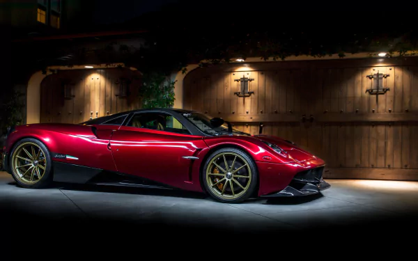 A striking red Pagani Huayra supercar parked in front of a wooden gate, showcased in 4K Ultra HD as a PC desktop wallpaper and background.