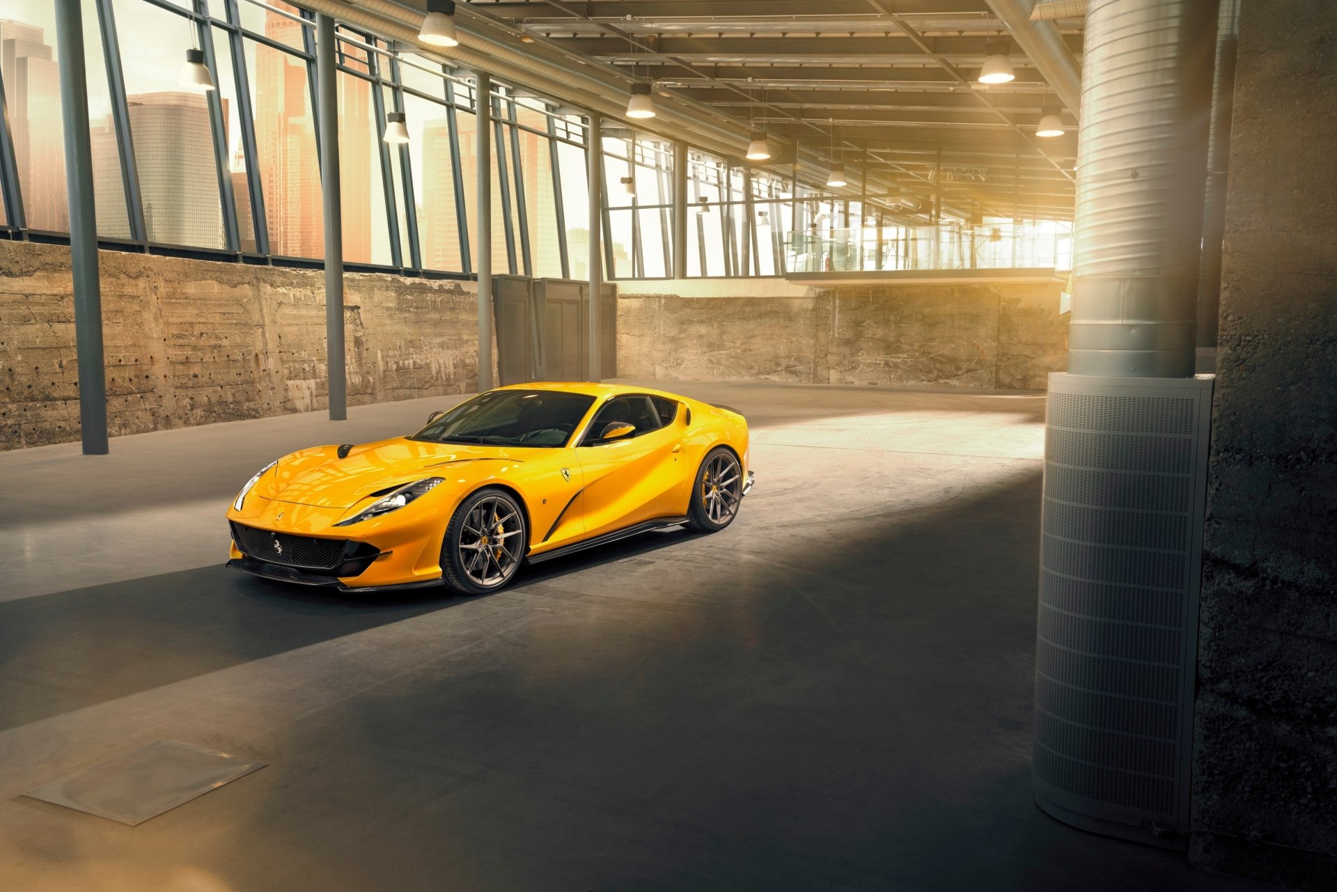 Yellow Ferrari 812 Superfast grand tourer supercar car parked in a sunlit industrial loft — 4K Ultra HD PC desktop wallpaper background.