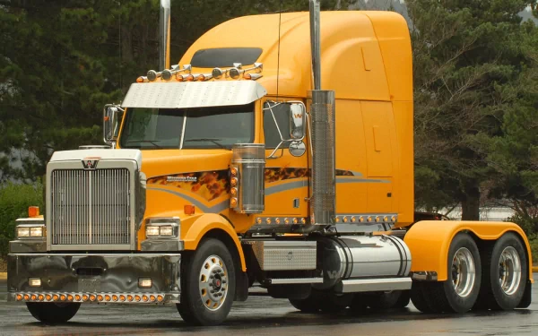 HD desktop wallpaper featuring a bright yellow Western Star semi-truck parked on a road with trees in the background.