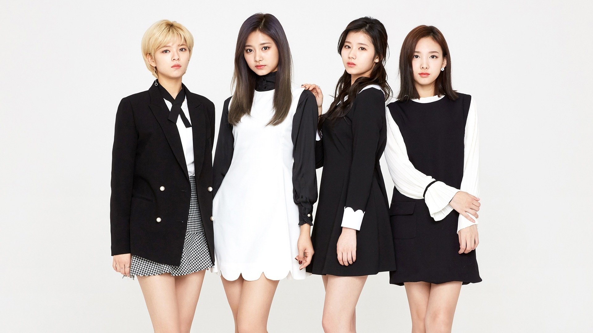 HD PC desktop wallpaper: four K-pop singers in coordinated black-and-white outfits posing against a white backdrop, stylish promotional music group portrait.