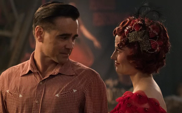 HD desktop wallpaper: still from the movie Dumbo (2019) showing two costumed characters — a man in a checkered shirt and a woman in a red beaded dress and ornate headpiece sharing a warm glance.