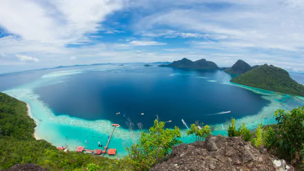 HD desktop wallpaper featuring a stunning fisheye view of the ocean and lush greenery along the coastline in Malaysia. Vibrant blues and greens capture the serene beauty of nature and the sea.