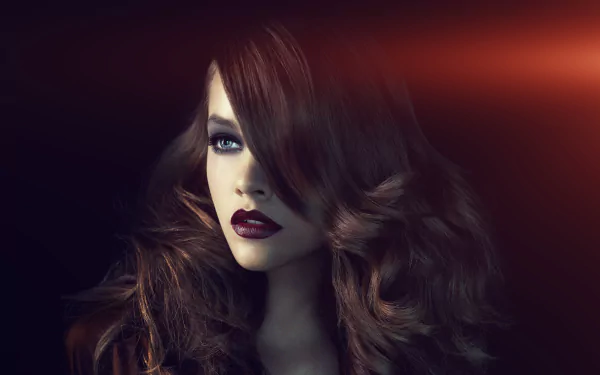 HD desktop wallpaper featuring a close-up of brunette Hungarian model Barbara Palvin with striking blue eyes and dark lipstick against a dark, softly lit background.
