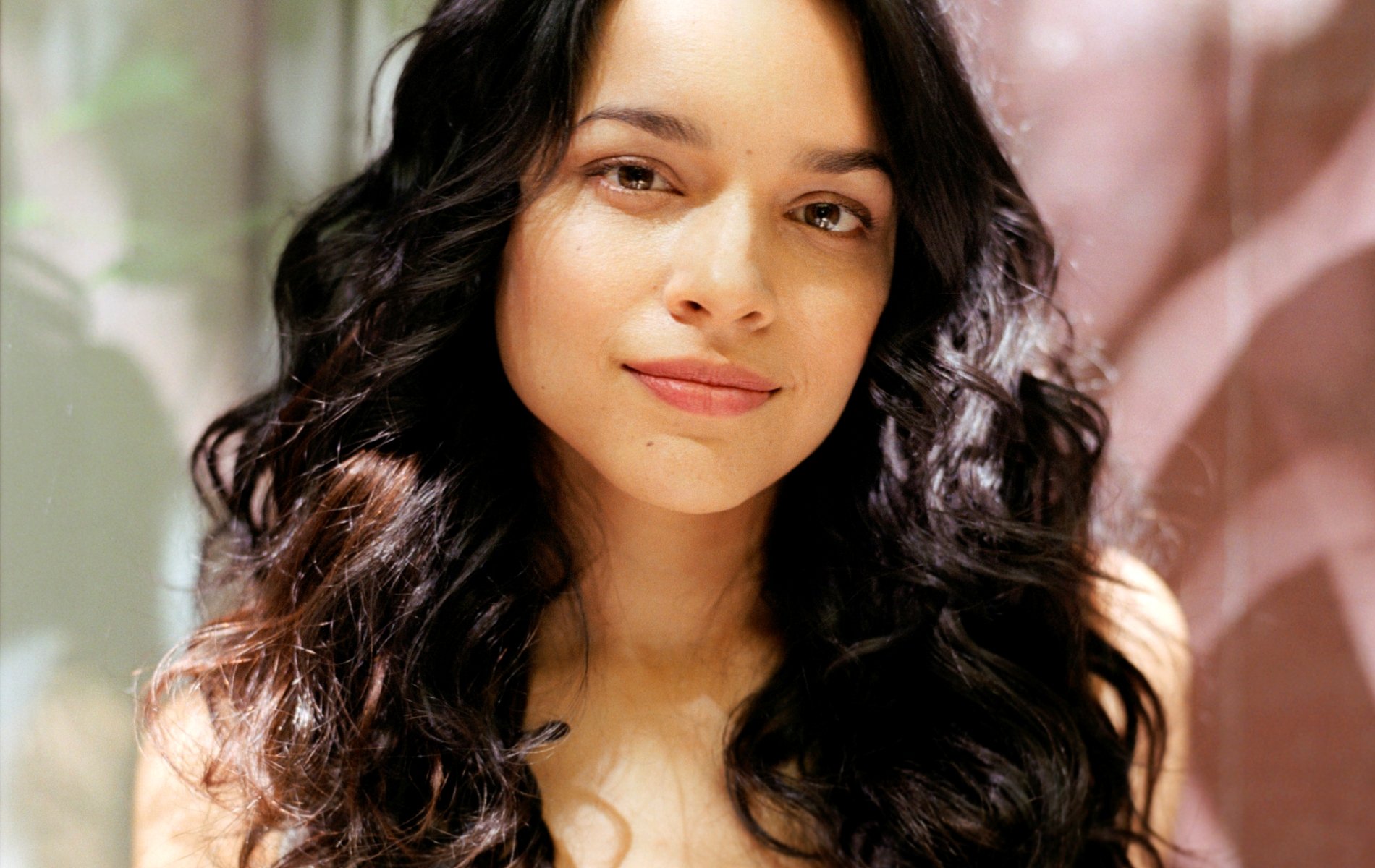 HD desktop wallpaper featuring a close-up portrait of Norah Jones, highlighting her natural beauty with soft lighting and a blurred background.