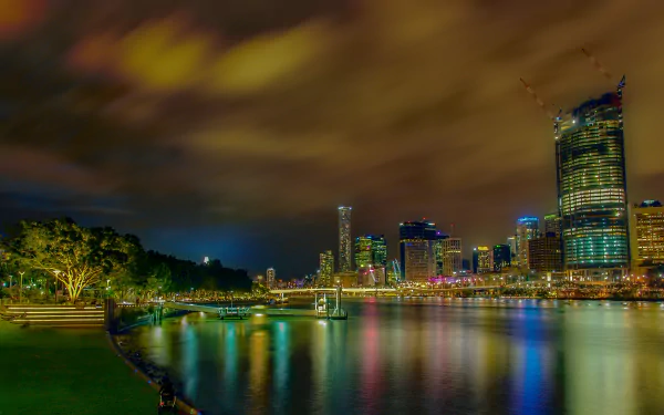 Night view of Brisbane city in Australia, showcasing illuminated skyscrapers and vibrant reflections on the river, captured in 4K Ultra HD quality.