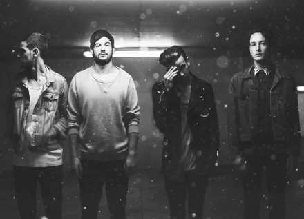 HD wallpaper featuring a monochrome shot of The 1975 band members standing in a dimly lit setting with a dusty atmosphere.